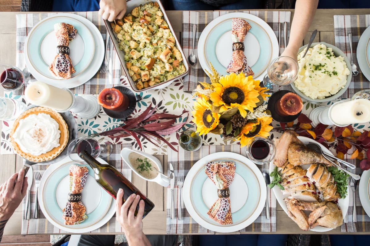 A table set for Thanksgiving with turkey, mashed potatoes, stuffing, and pumpkin pie.
