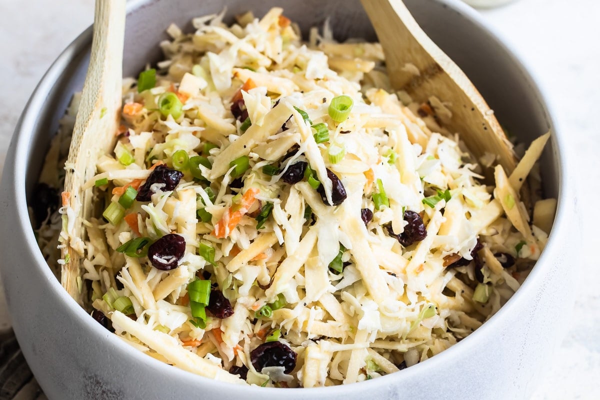 A serving bowl filled with apple coleslaw.