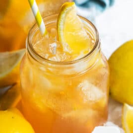 An arnold palmer in a mason jar with a lemon wedge garnish.