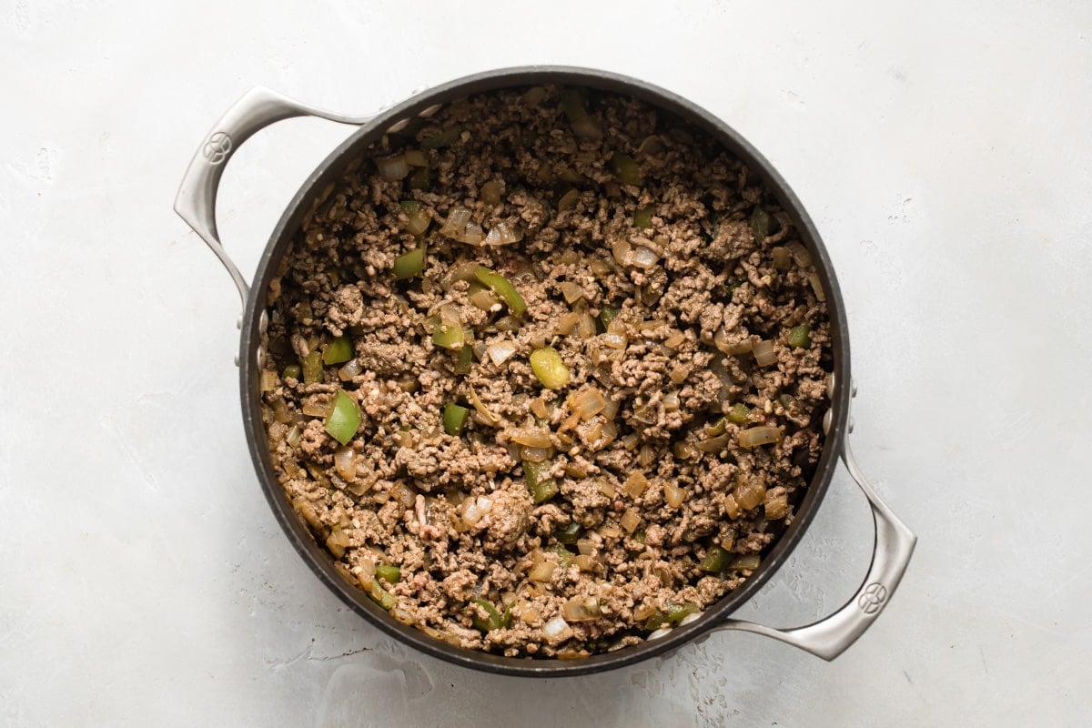 Cooked ground beef and chopped vegetables in a black pot.