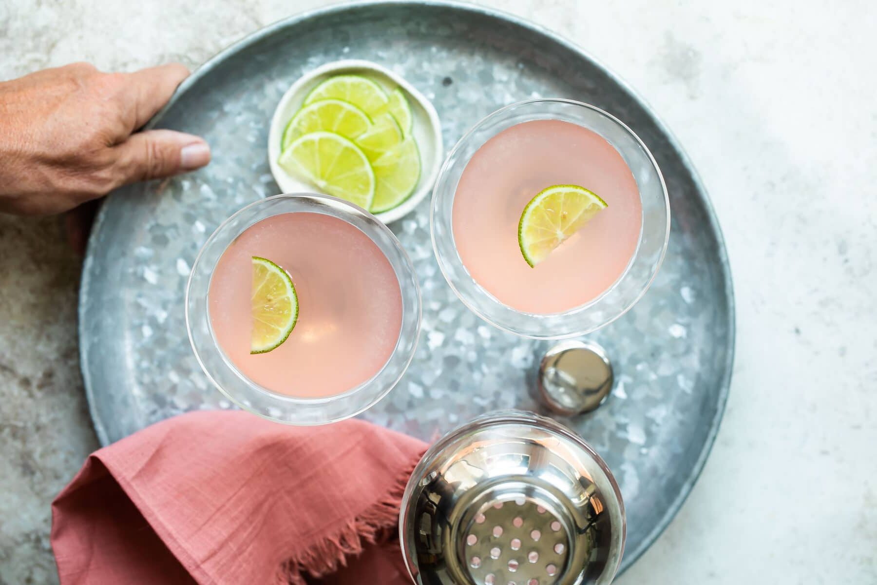 Two cosmopolitan cocktails on a tray.
