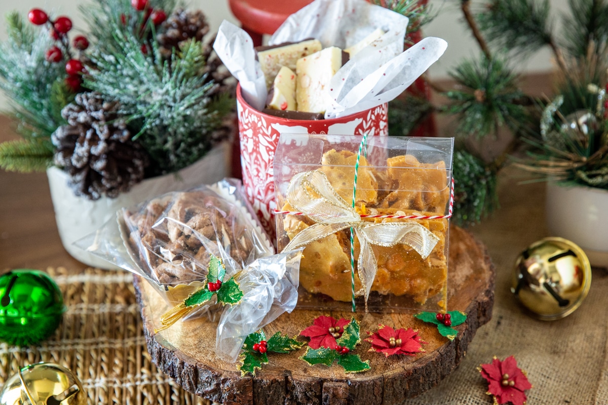 Candied pecans, peanut brittle, and peppermint bark wrapped for Christmas.
