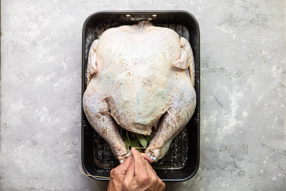 Trussing a raw turkey.