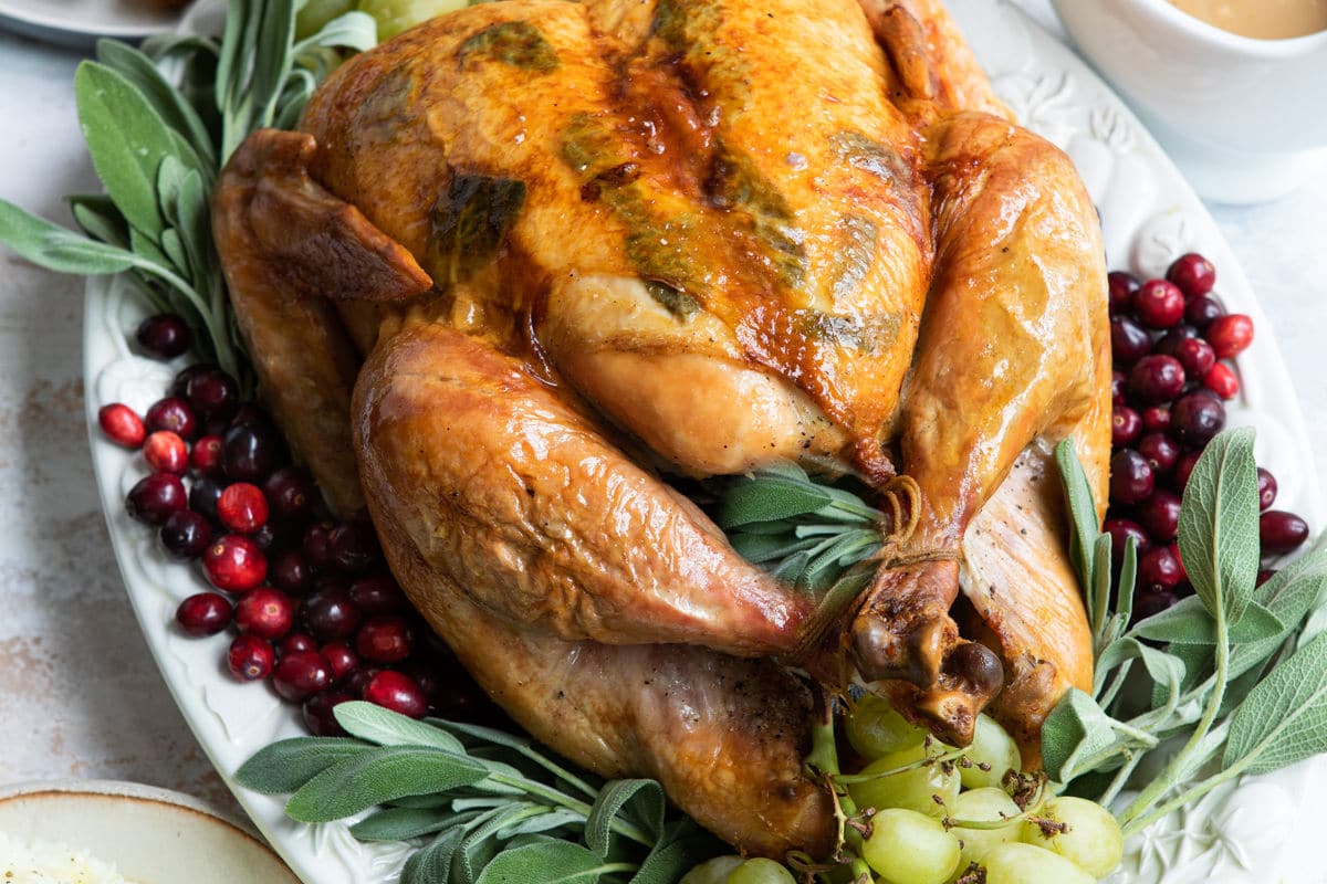 A platter of roast turkey garnished with grapes.