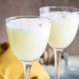 Two Pisco Sours in Nick and Nora glasses.