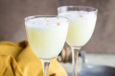 Two Pisco Sours in Nick and Nora glasses.