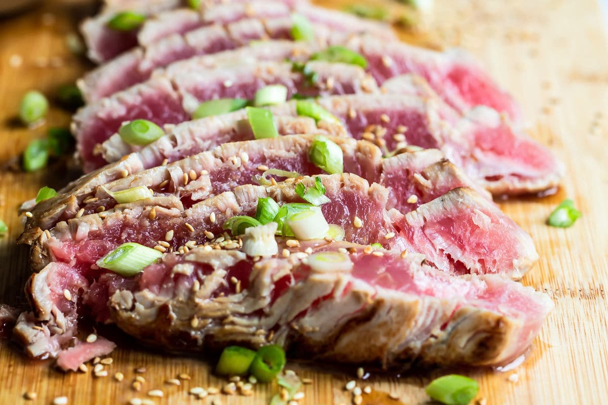 Ahi tuna on a wooden cutting board.