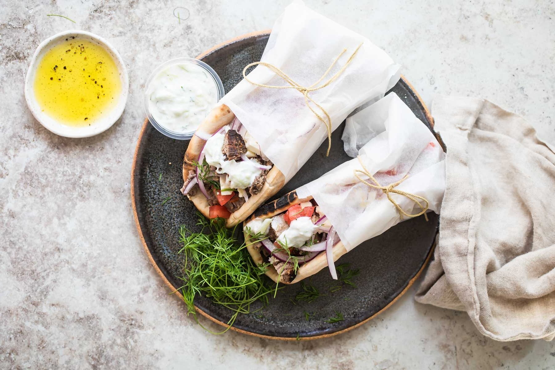 Two wrapped beef gyros on a plate.