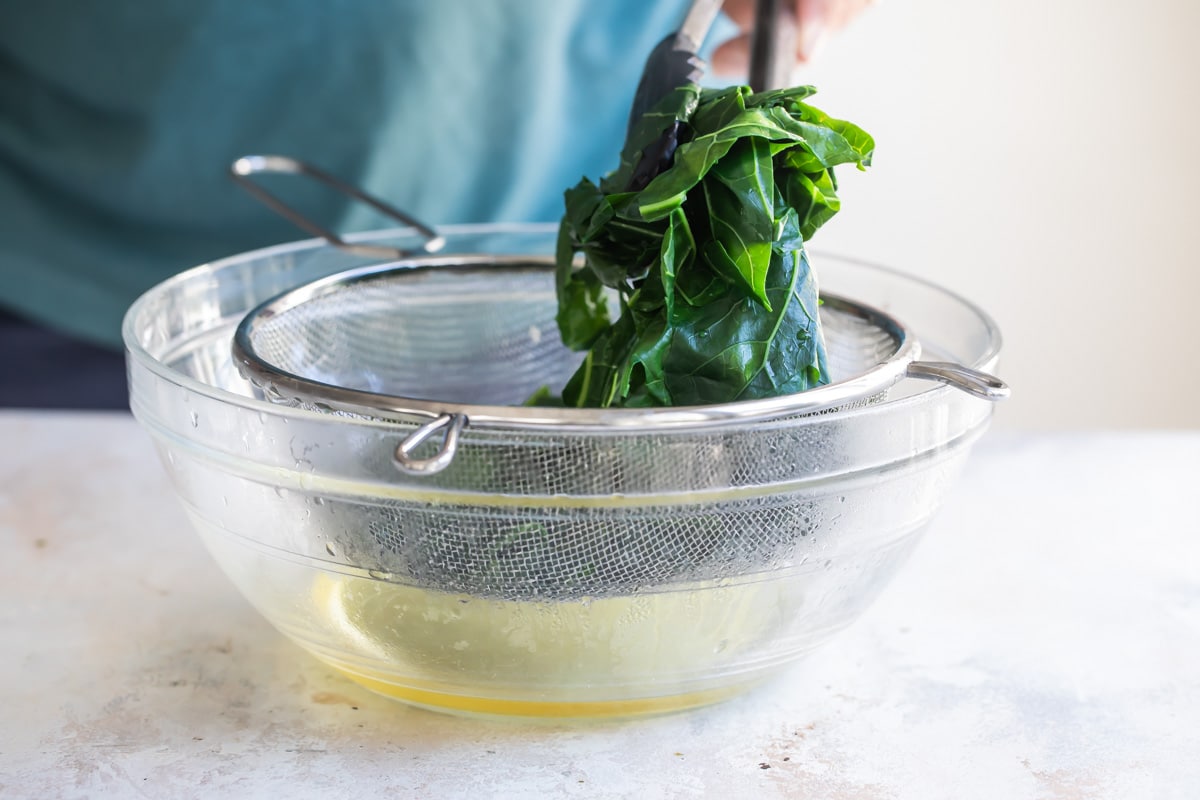Draining collard greens after cooking.