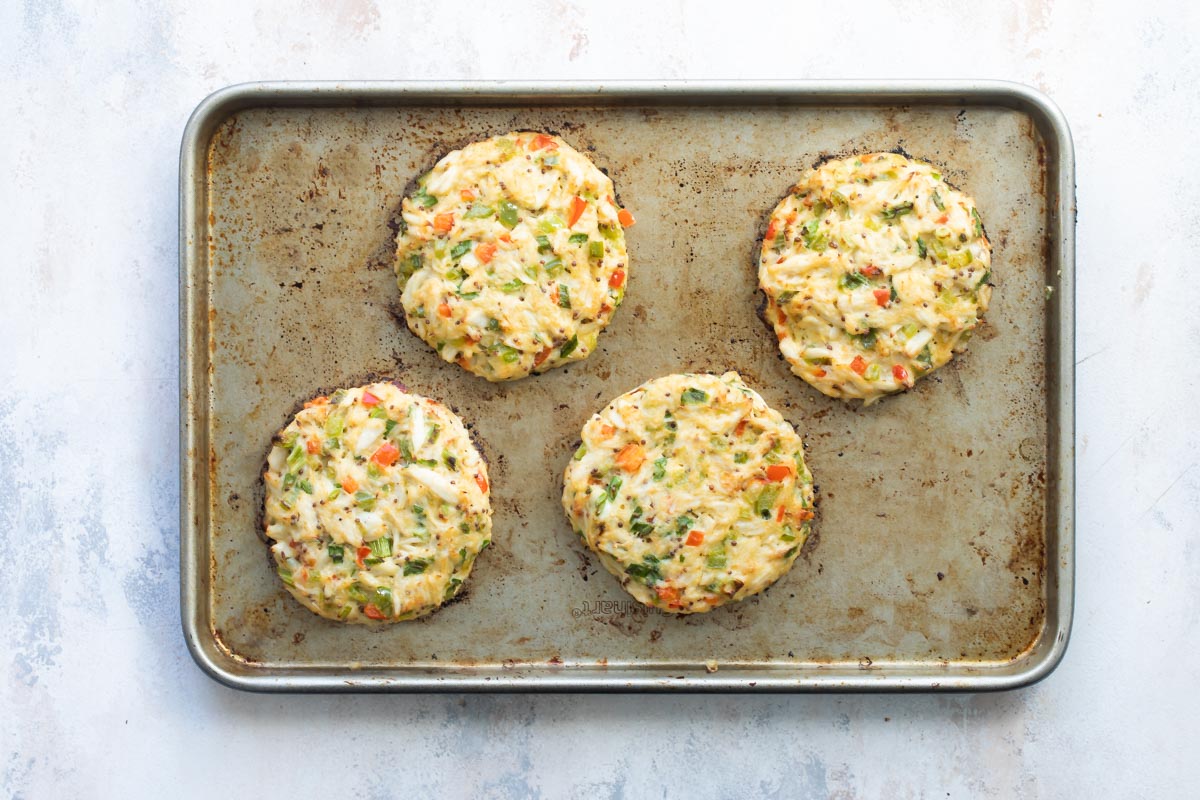 Crab cakes on a baking sheet after being in the oven.
