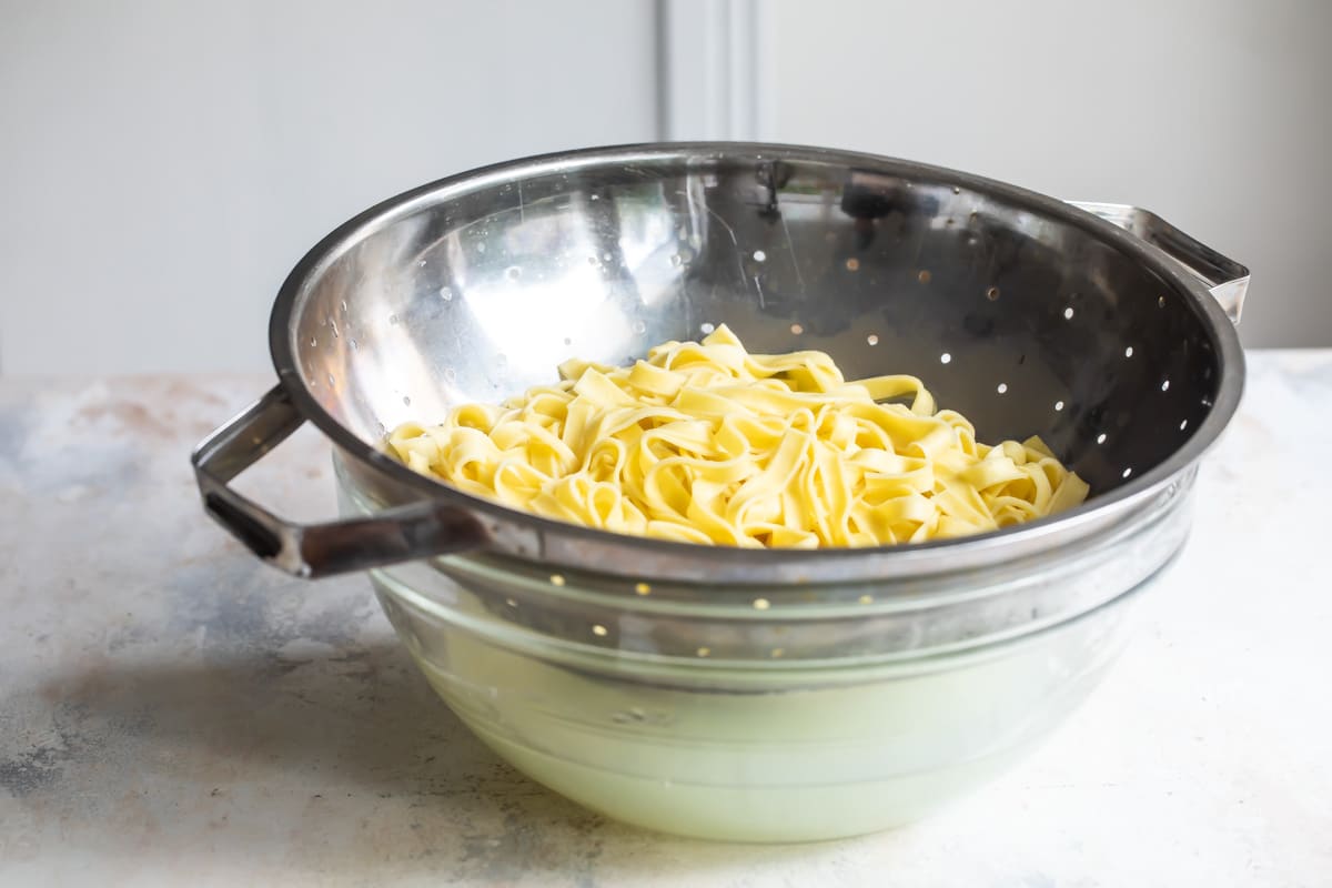 Fettuccine draining in a colander.