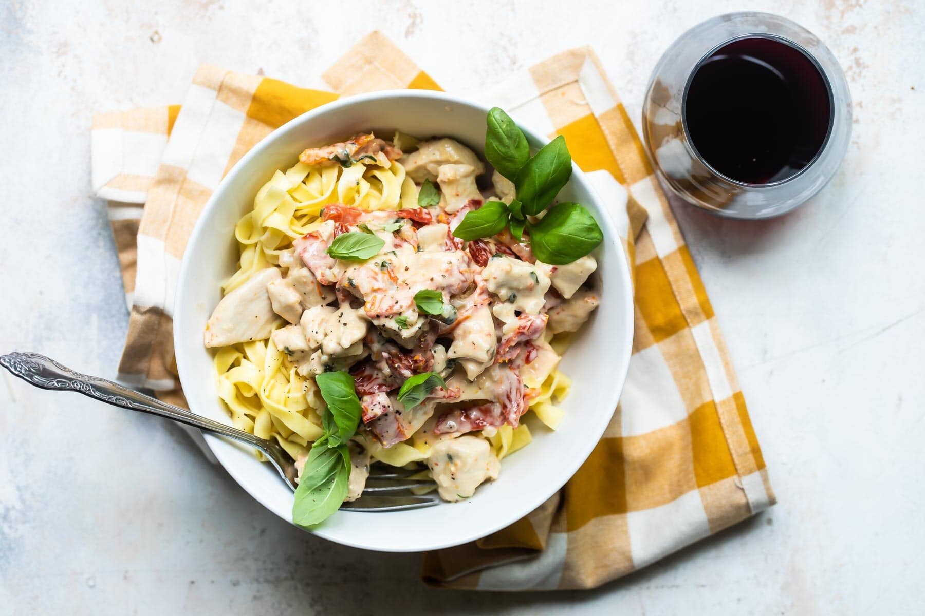 A serving bowl of creamy chicken pasta.