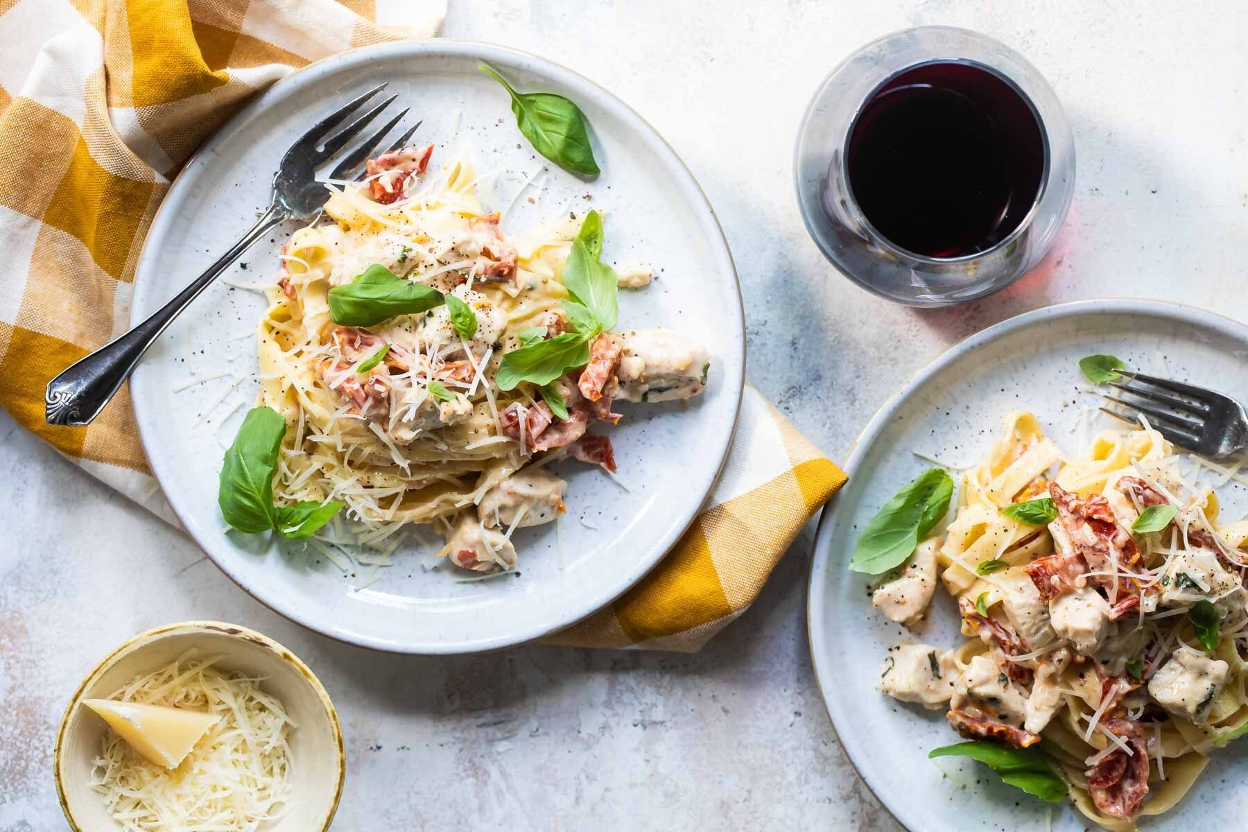 Two plates of creamy chicken pasta.