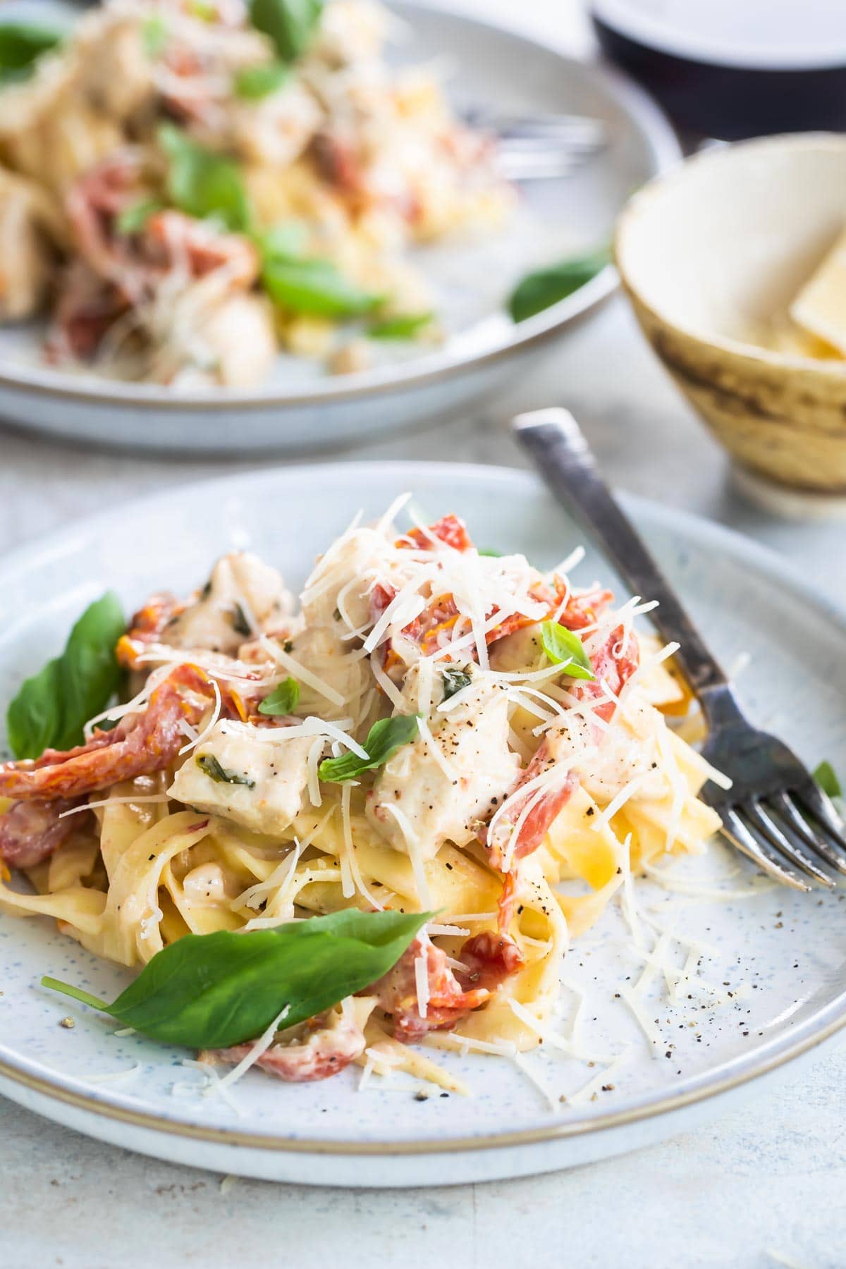 Two plates of creamy chicken pasta.