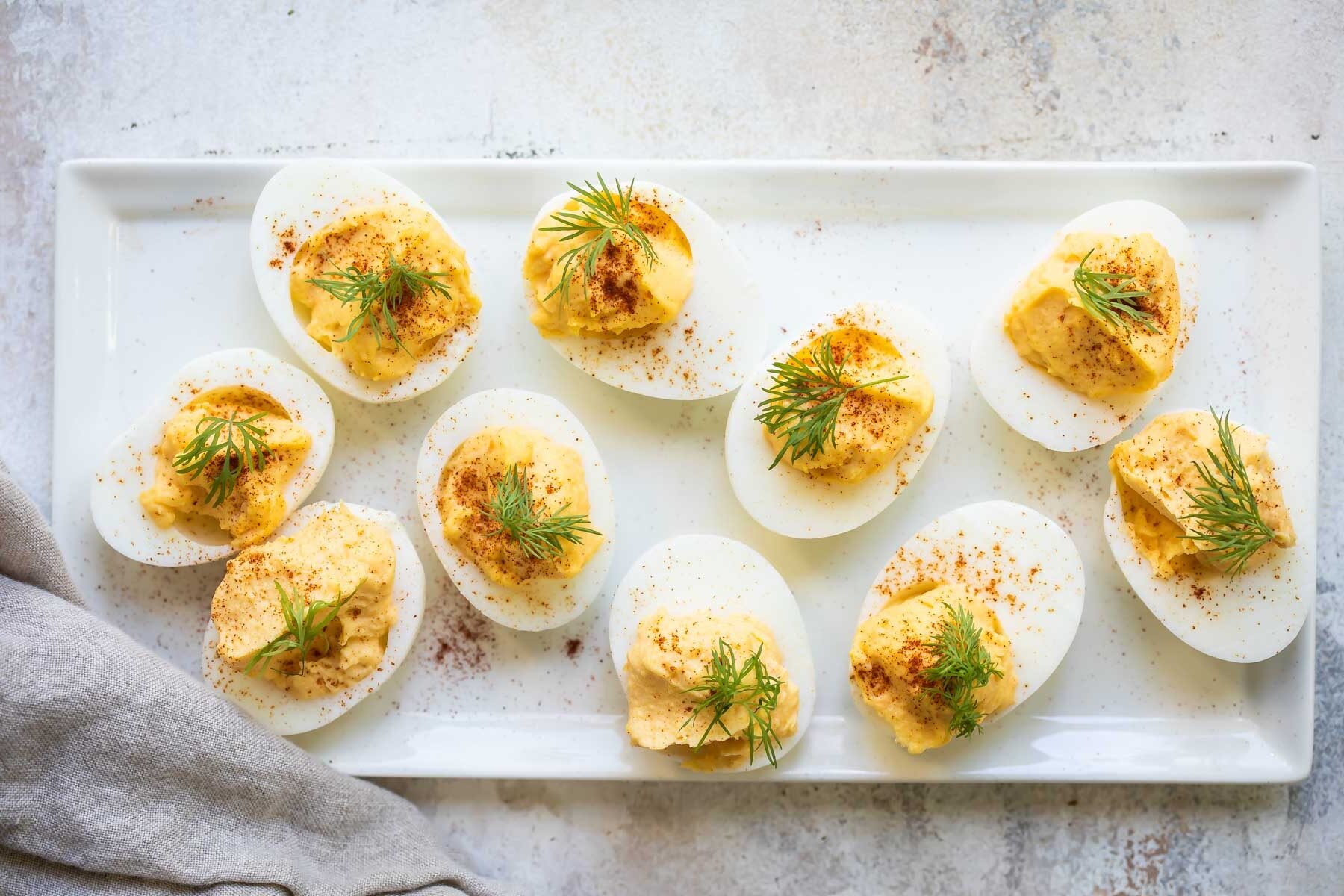Deviled eggs on a rectangular white platter.