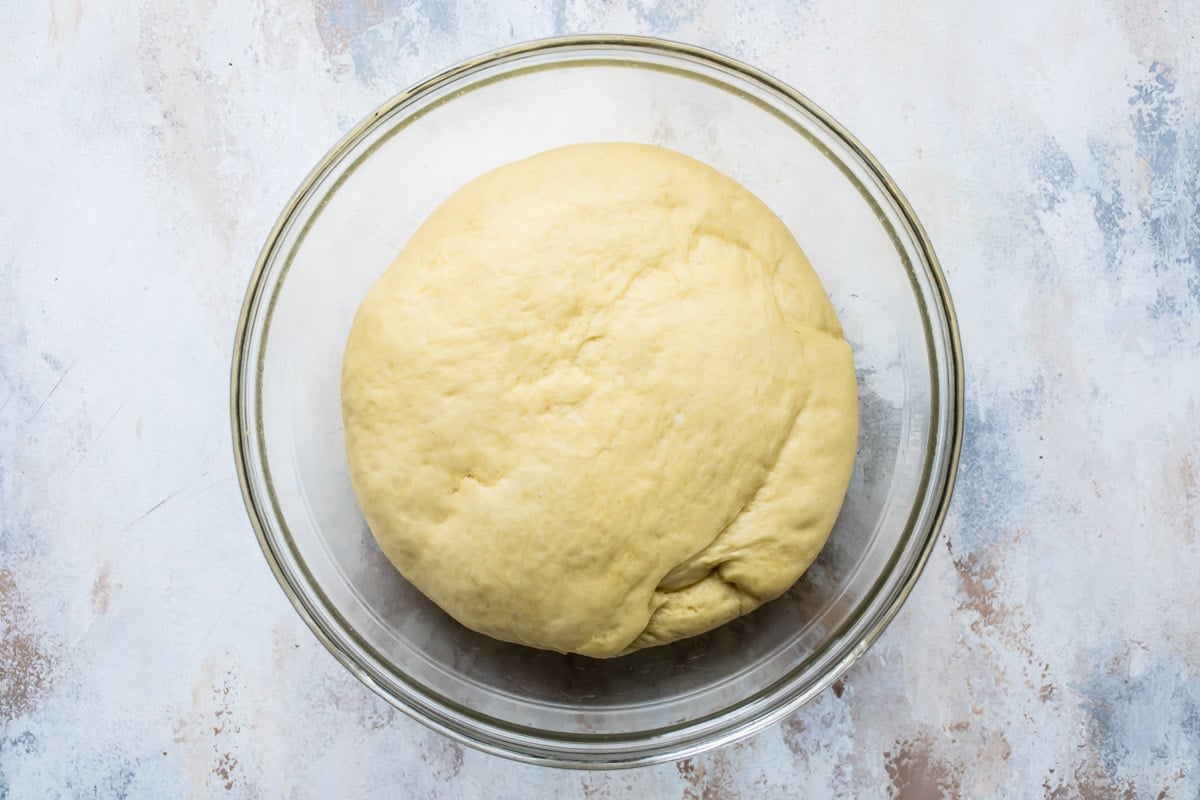 King cake dough in a clear mixing bowl.