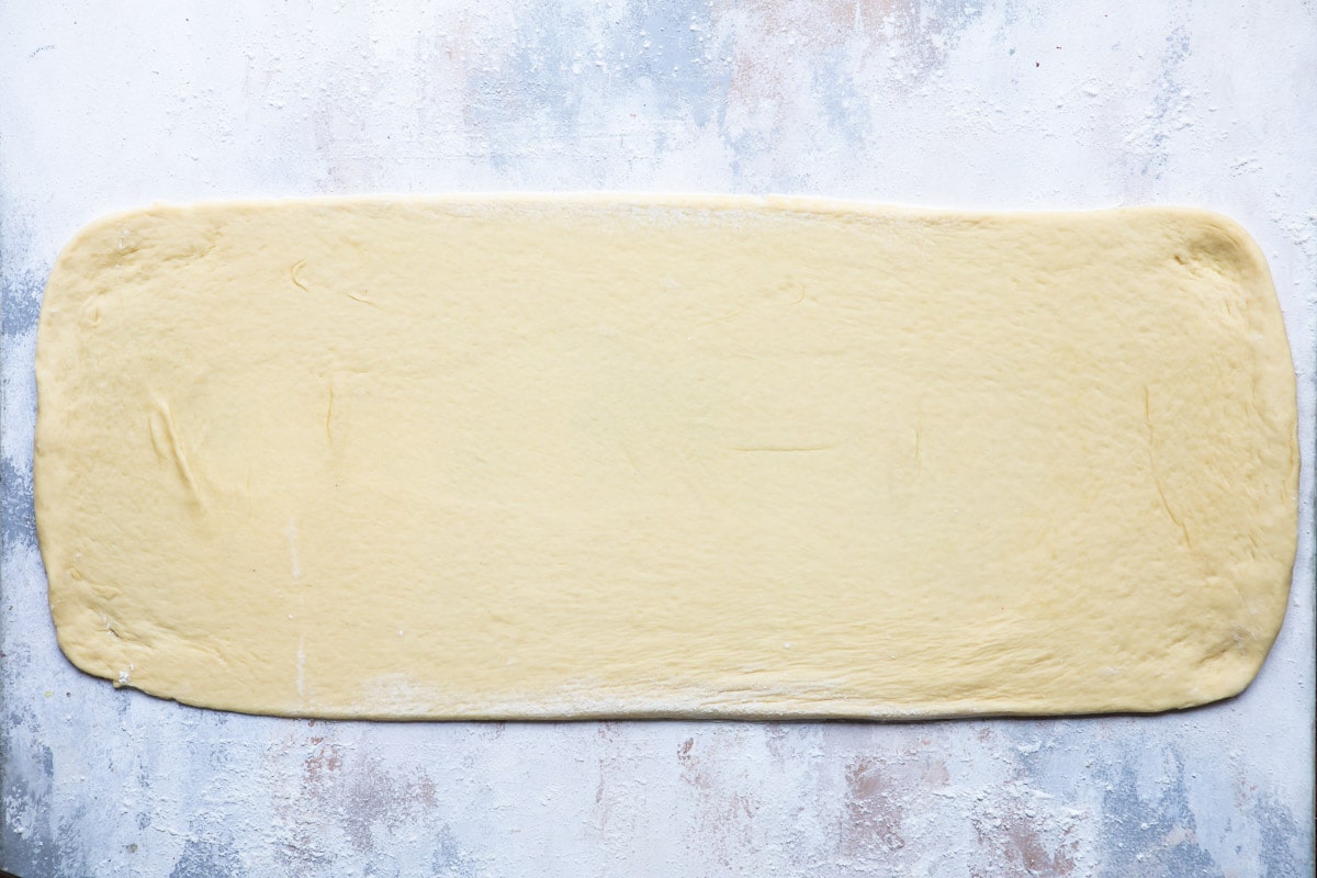 King cake dough rolled out into a long rectangle.