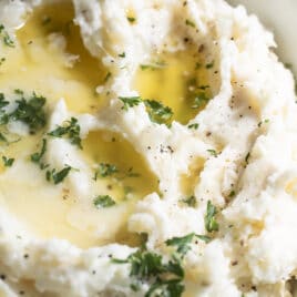 Make ahead mashed potatoes in a white bowl.