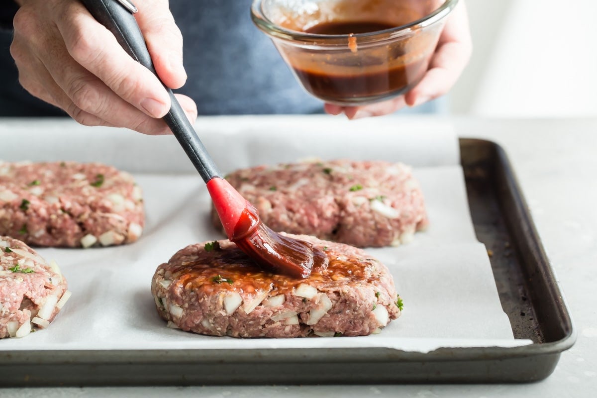 Brushing balsamic glaze on mini meatlovaes.