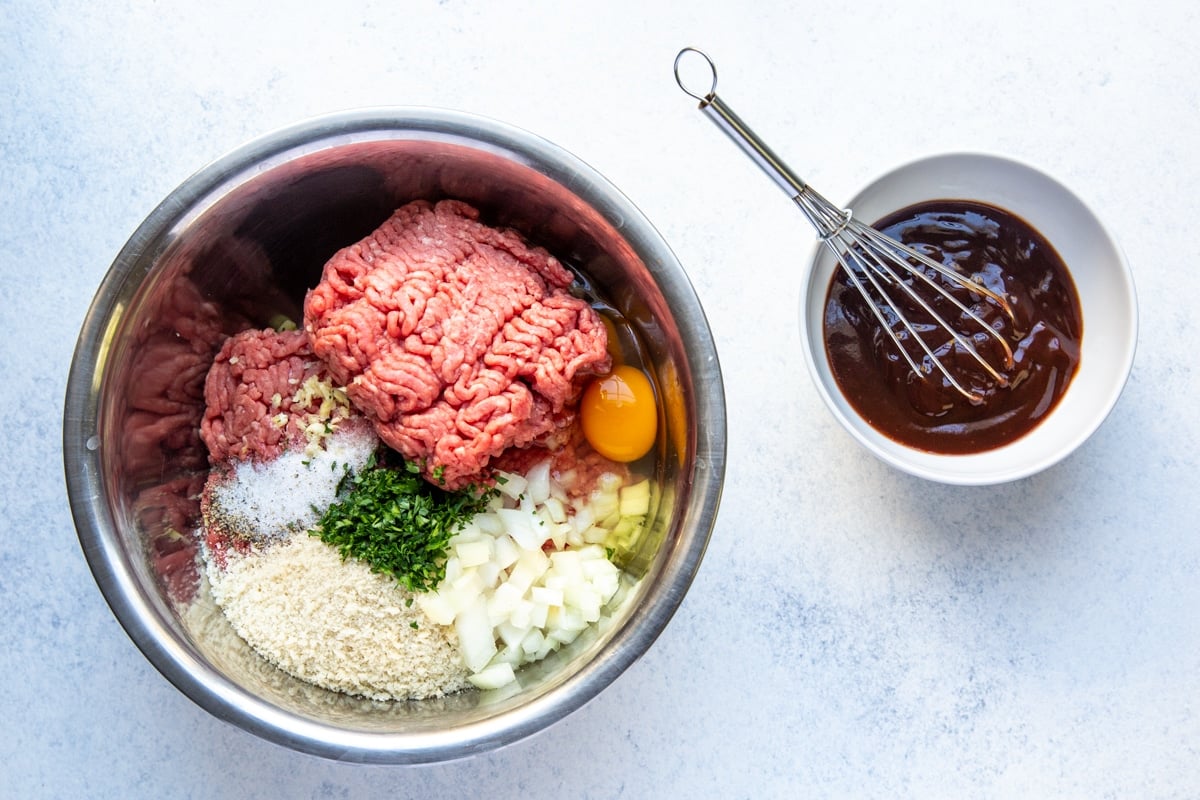 Mini meatloaf mix in a bowl with balsamic glaze nearby.