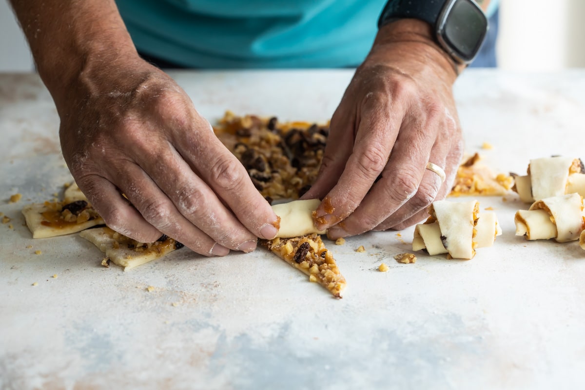 Someone rolling rugelach on a countertop.