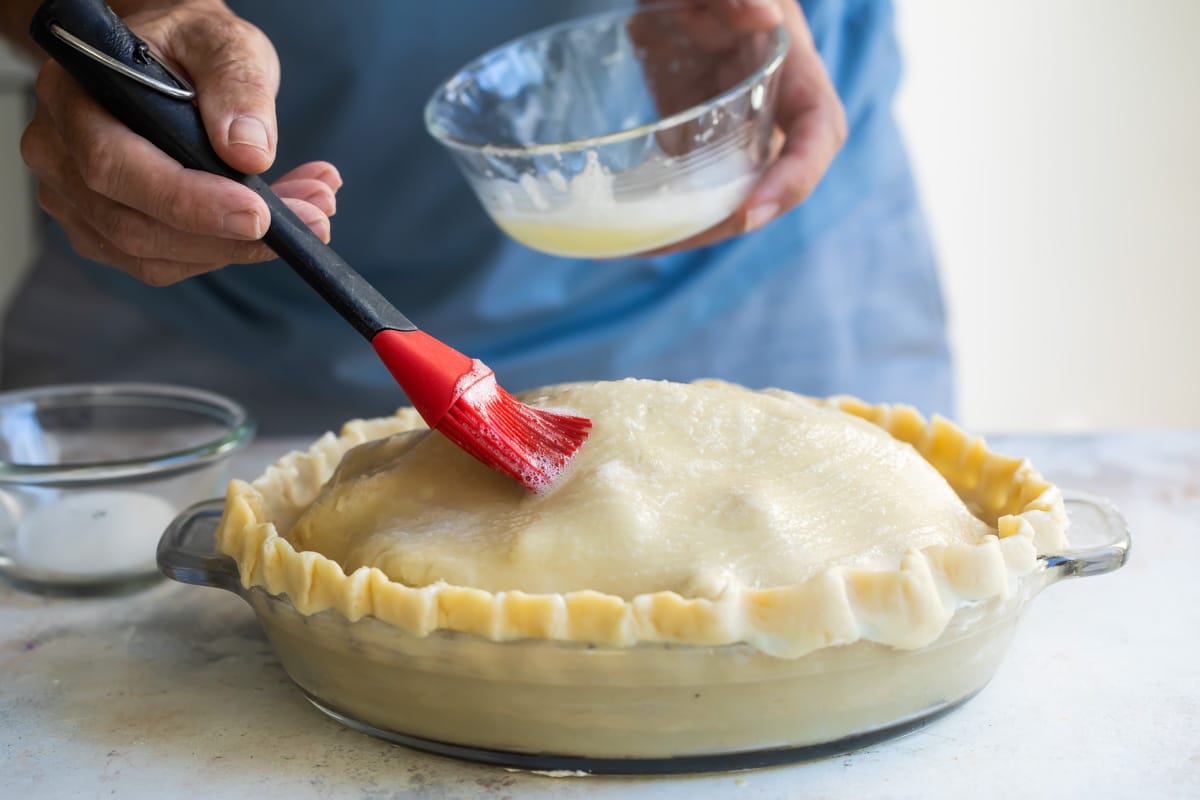 Brushing egg was on an unbaked apple pie.