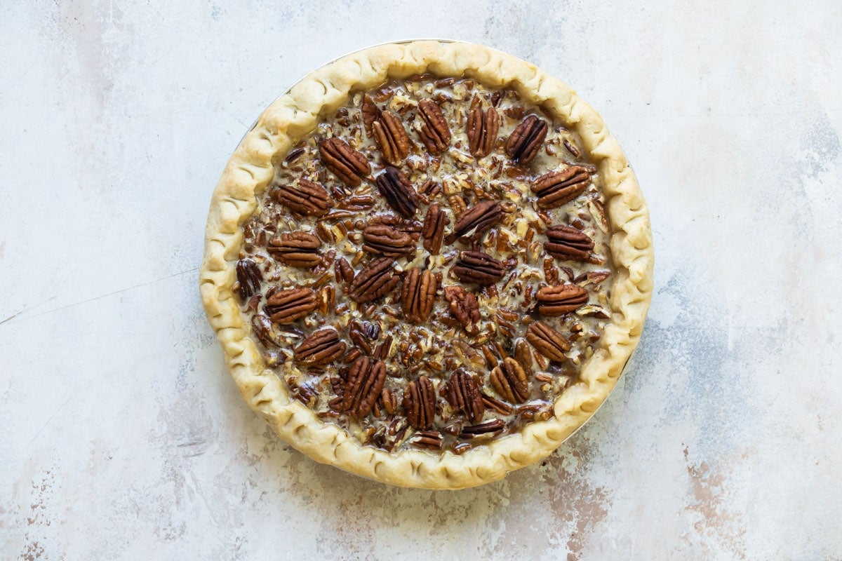 An unbaked pecan pie (unsliced).