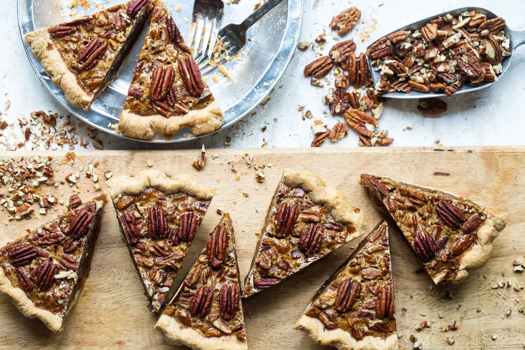 Slices of pecan pie on a board.