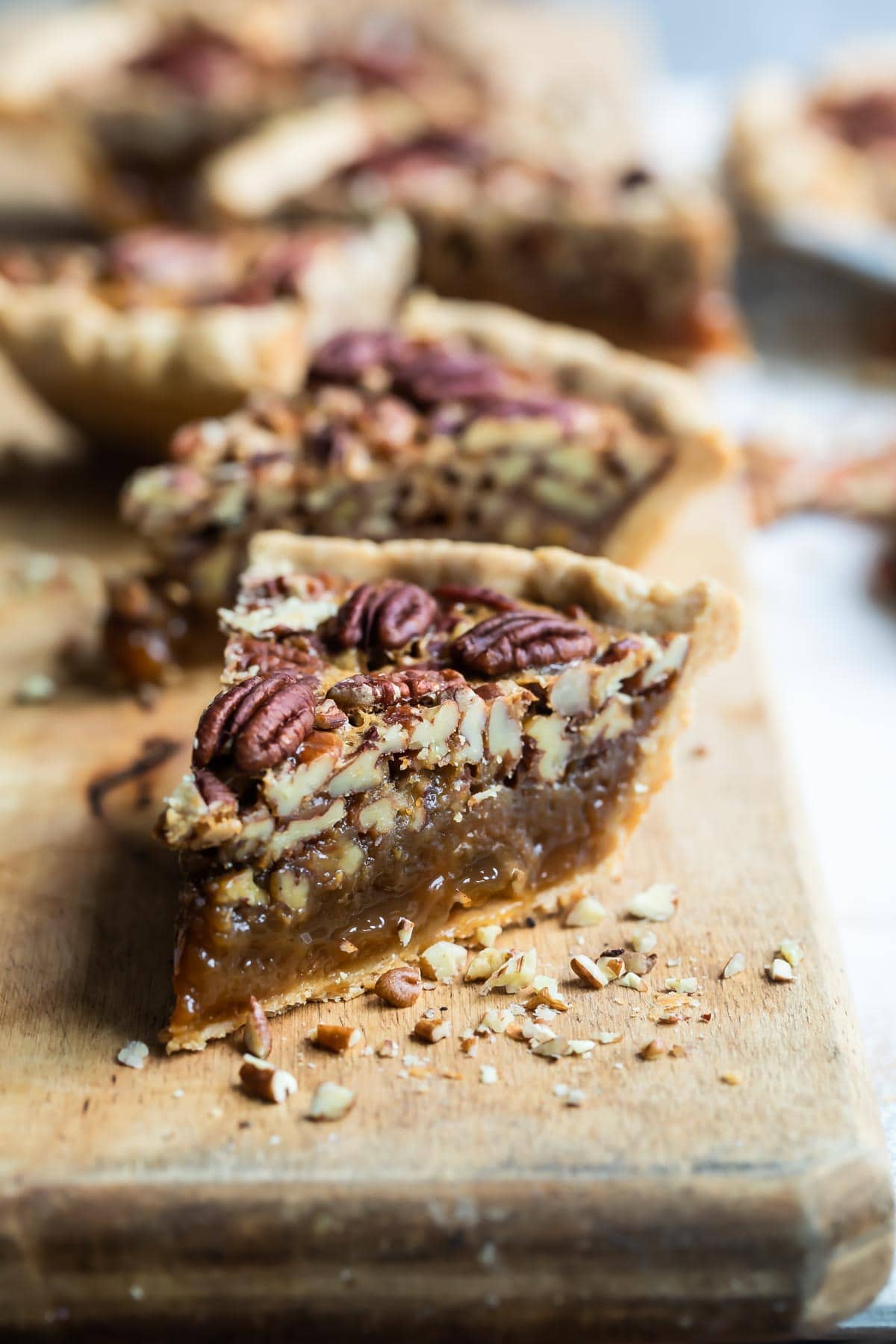 Slices of pecan pie on a board.
