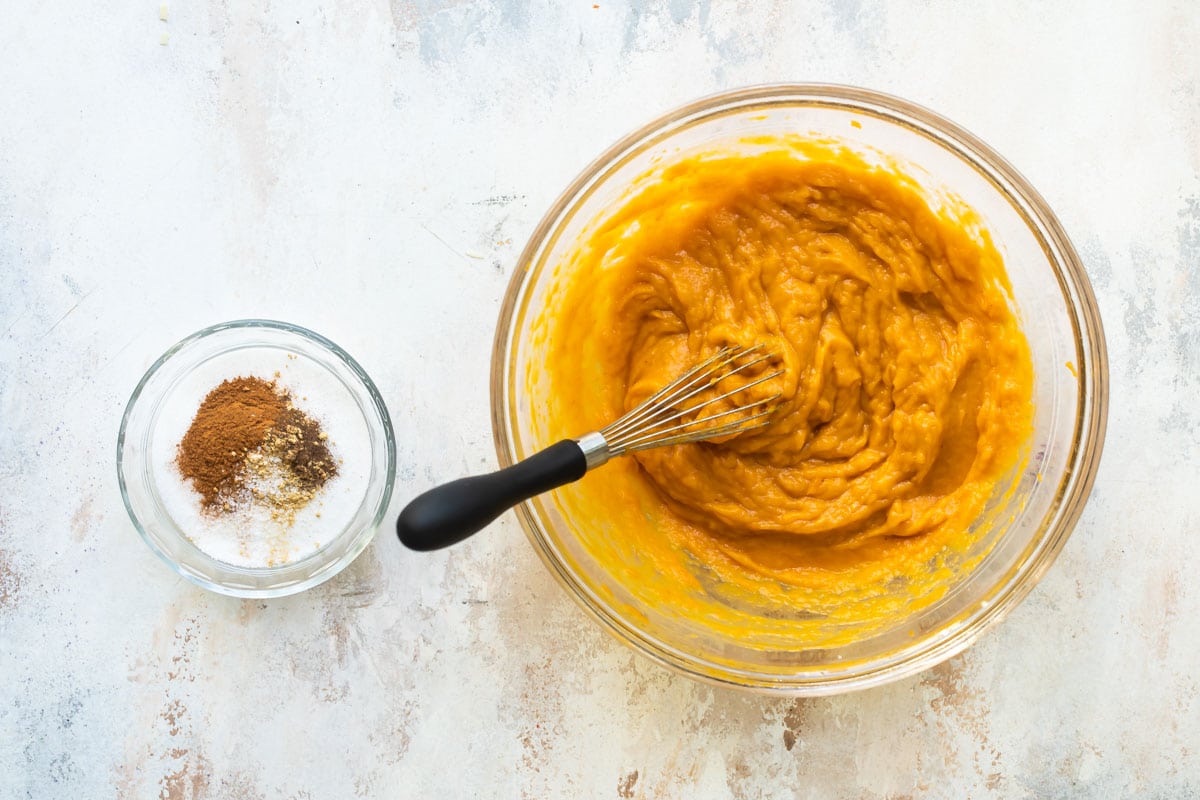 Mixing up pumpkin pie filling in a bowl.