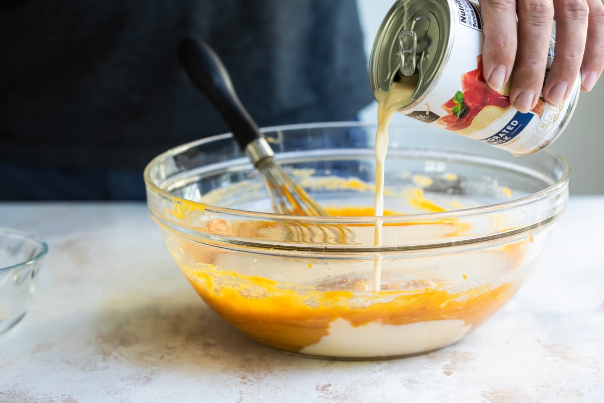 Mixing up pumpkin pie filling in a bowl.