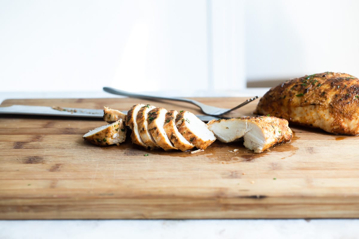 Blackened chicken on a wooden cutting board.