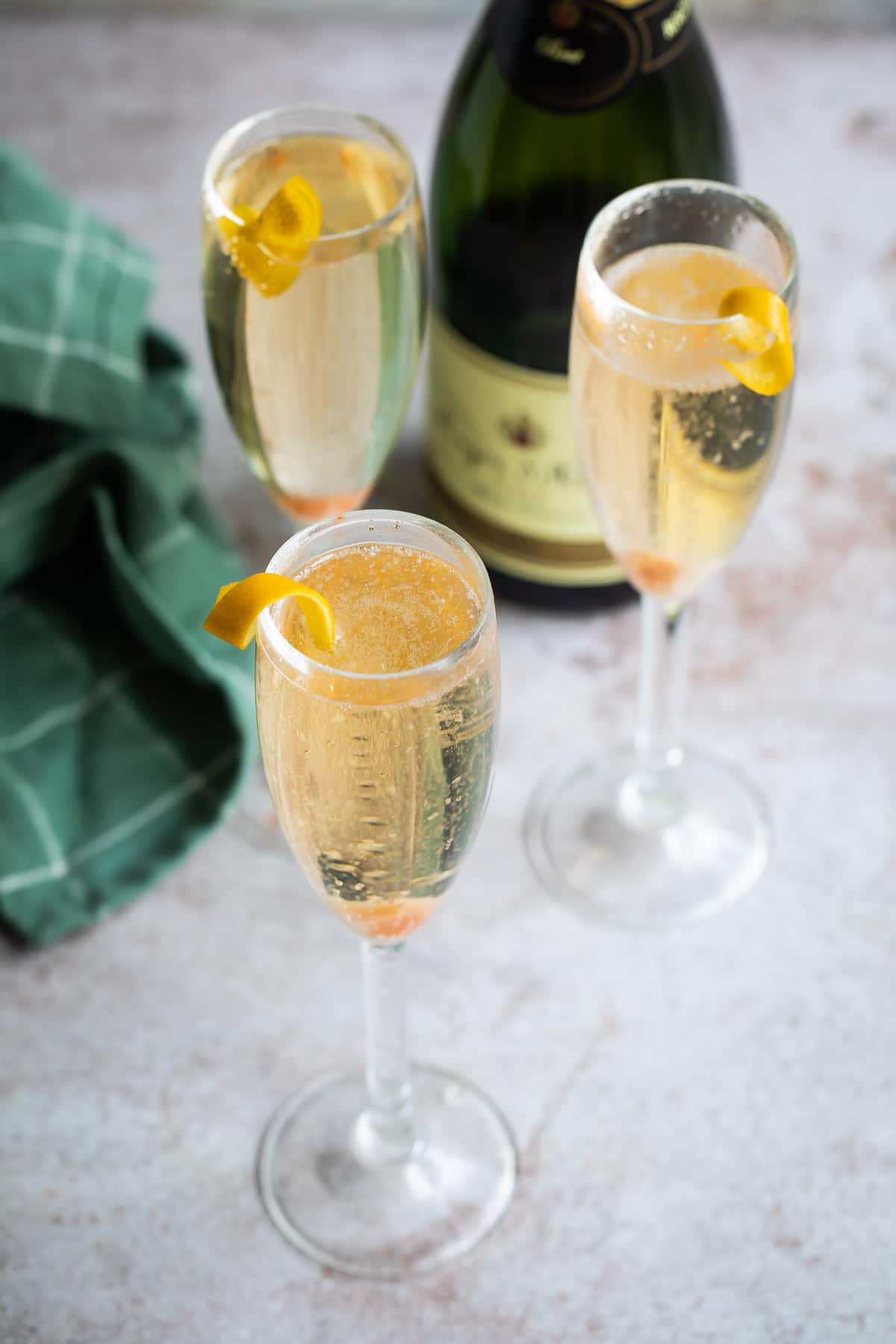 Three champagne cocktails in a champagne flutes.