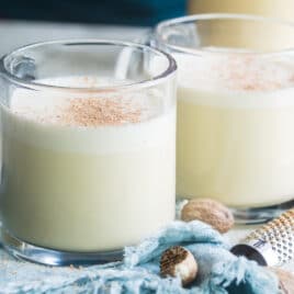 Two clear mugs filled with eggnog.