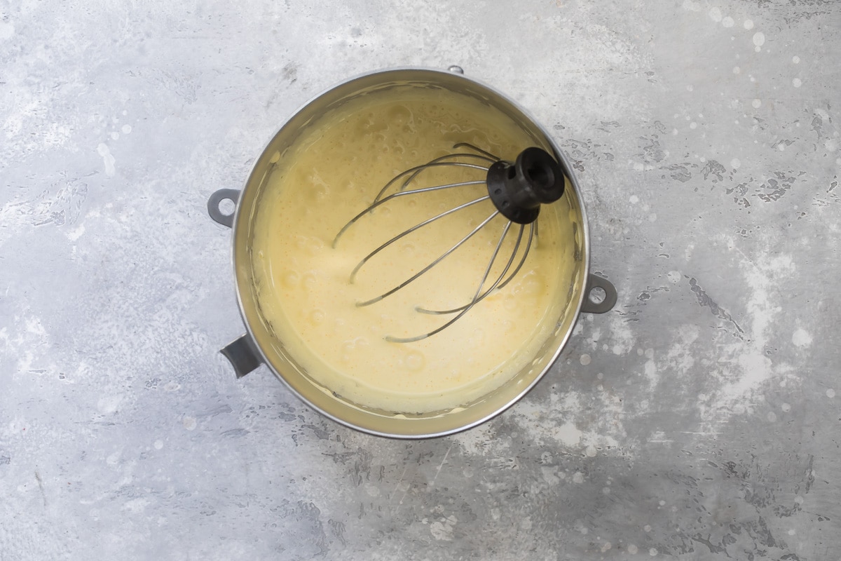 Cream colored batter in a mixing bowl with the whisk attachment resting in it.