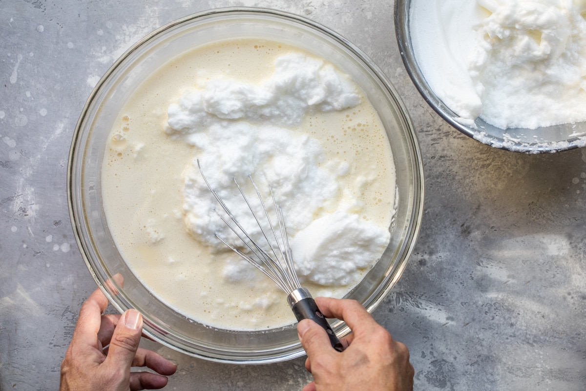 Eggnog being mixed in a clear bowl.