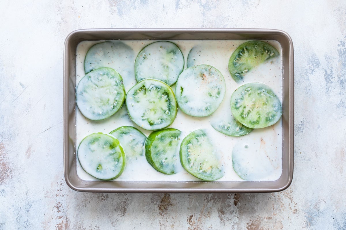 Soaking green tomatoes in buttermilk for Fried Green Tomatoes.