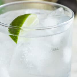 A gin and tonic cocktail in a clear glass.