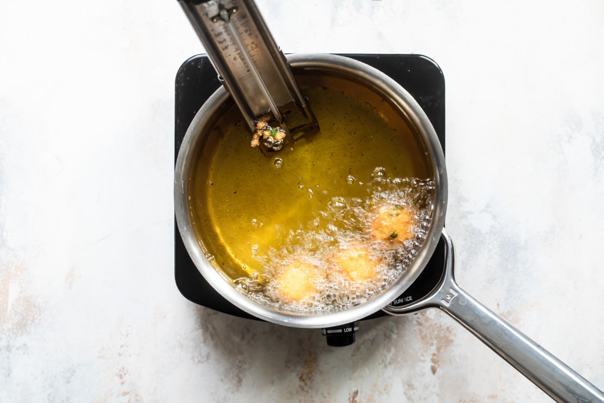 Hush puppies being deep fried.