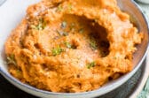Mashed sweet potatoes in a gray bowl.
