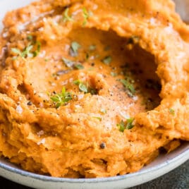 Mashed sweet potatoes in a gray bowl.