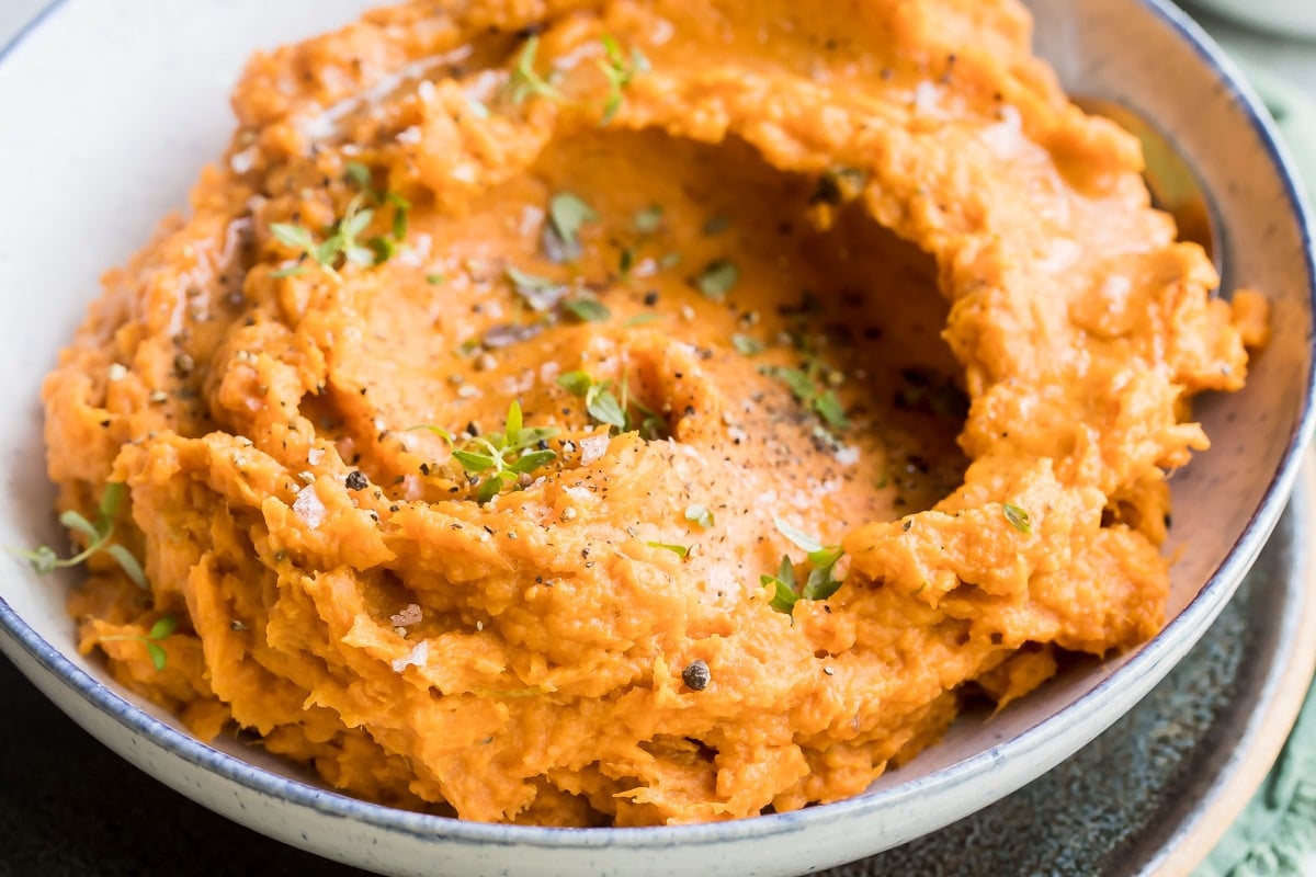 Mashed sweet potatoes in a gray bowl.