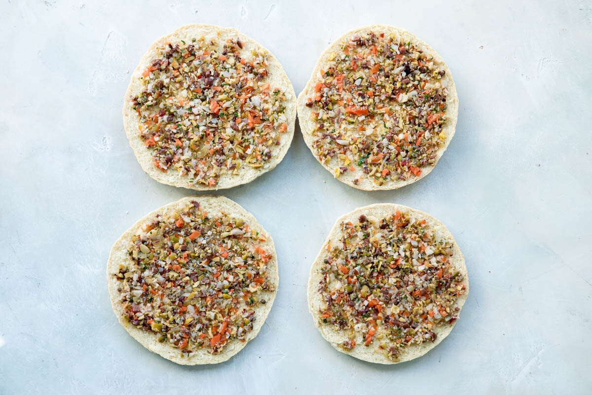 Muffaletta bread halves topped with muffaletta mixture.