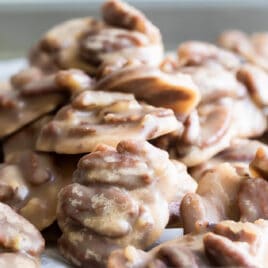 A stack of pecan pralines on a baking sheet.