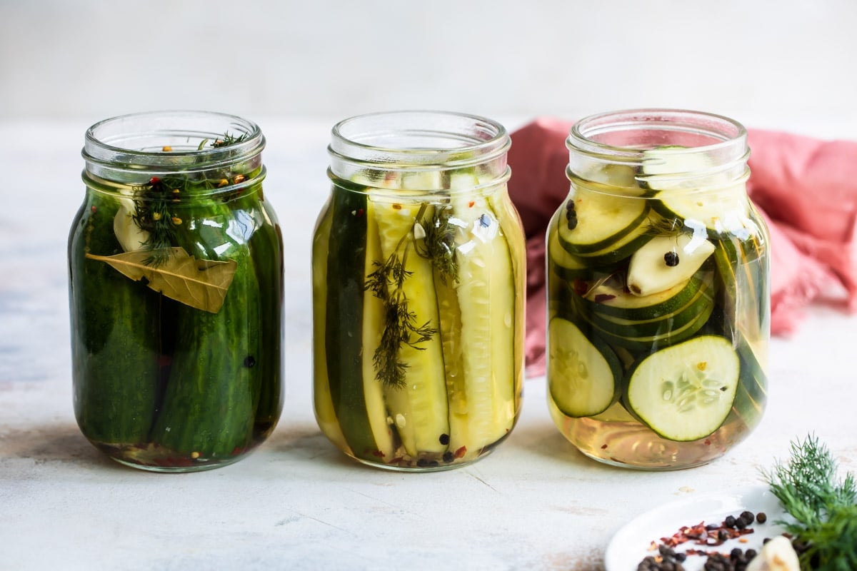 Three mason jars filled with pickles.