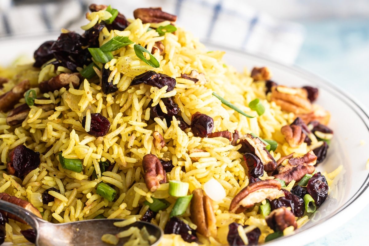 A plate of rice stuffing with a spoon resting in it.