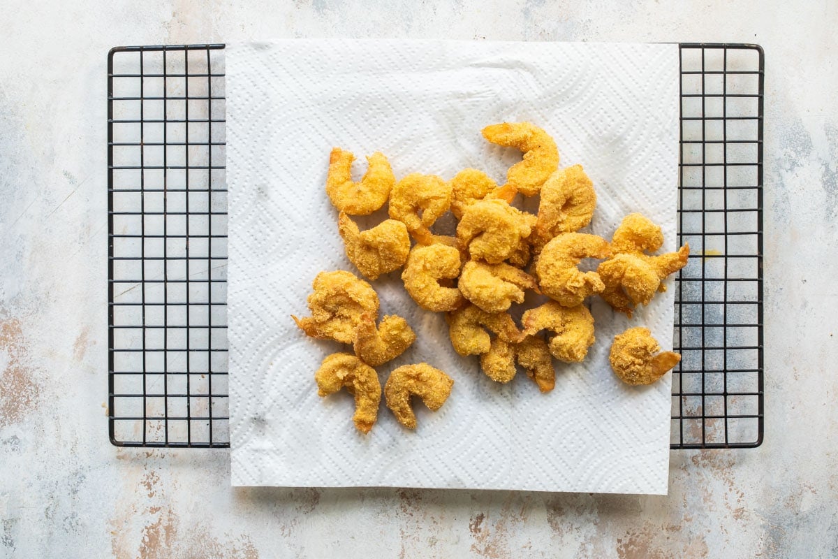 Shrimp resting on a paper towel lined cooling rack.