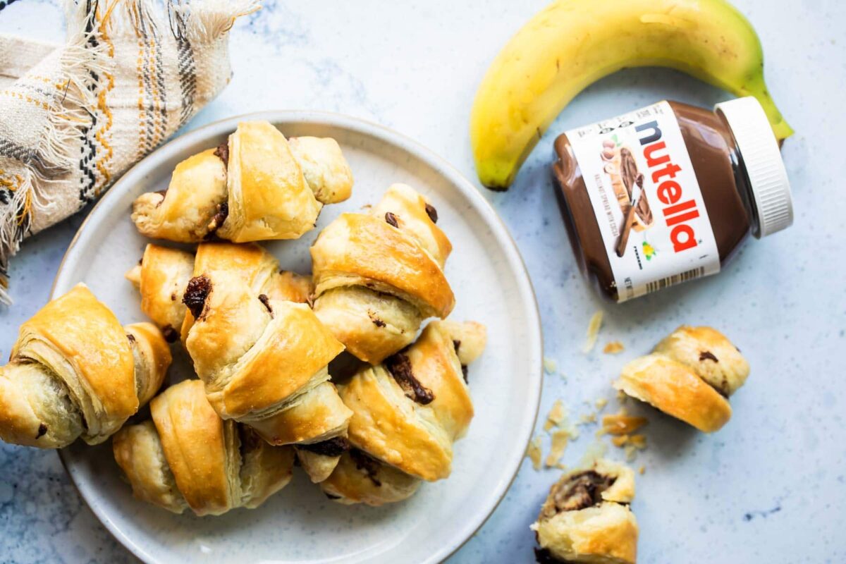Baked banana nutella croissants on a white plate.