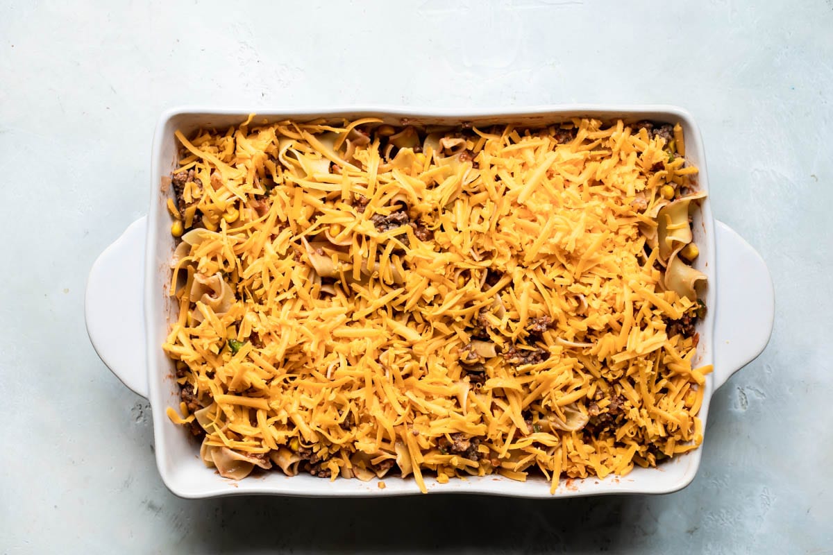 Beef noodle casserole in a white baking dish before being baked..