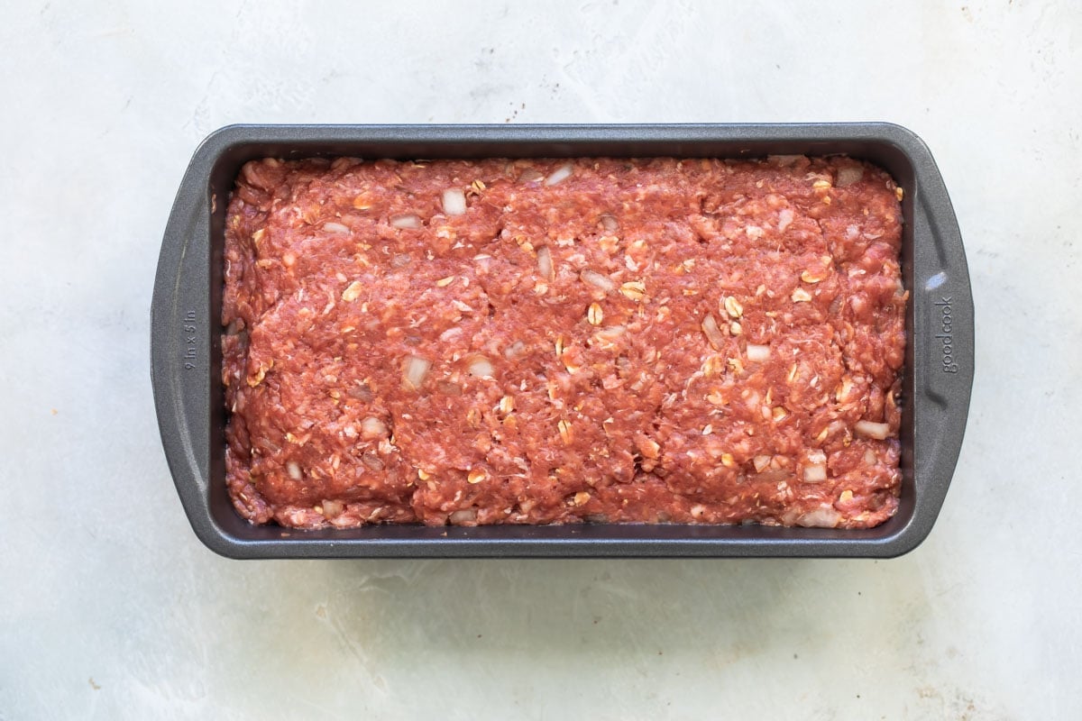 Cheesy meatloaf in a baking pan before being baked.